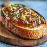 Bright homemade dandelion jelly with fresh lemon and honey, perfect for toast or yogurt in spring.  