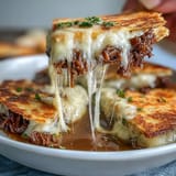 Melted cheese and juicy birria beef fill golden quesadillas, paired with warm consommé for a festive Mexican meal.  