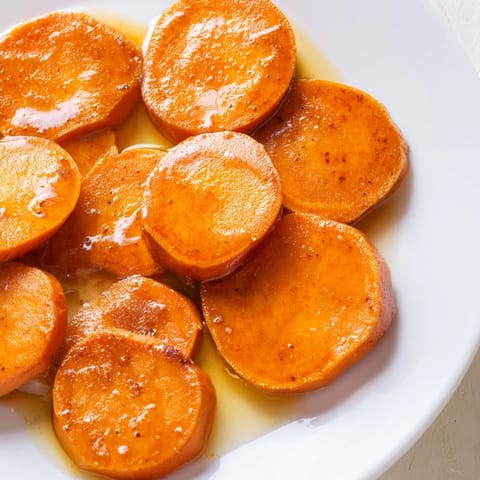 Golden-glazed candied yams, bubbling in a baking dish, a classic Southern Thanksgiving side.