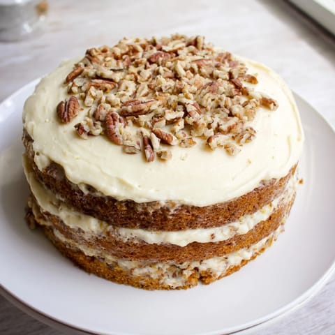 Fluffy slices of Hummingbird Cake, a Southern dessert with cream cheese frosting and pecans.