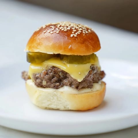 Juicy sliders mini hamburgers with melted cheese, pickles, and special sauce, ready to eat.