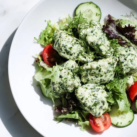 Freshly made Green Goddess Chicken Salad with vibrant herbs, creamy avocado, and juicy cherry tomatoes ready for a healthy lunch.  