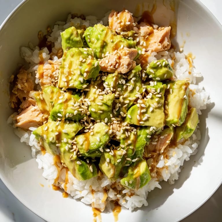 Serve this vibrant Tuna Avocado Rice Bowl for a quick, satisfying meal, drizzled with a savory ginger-soy dressing.