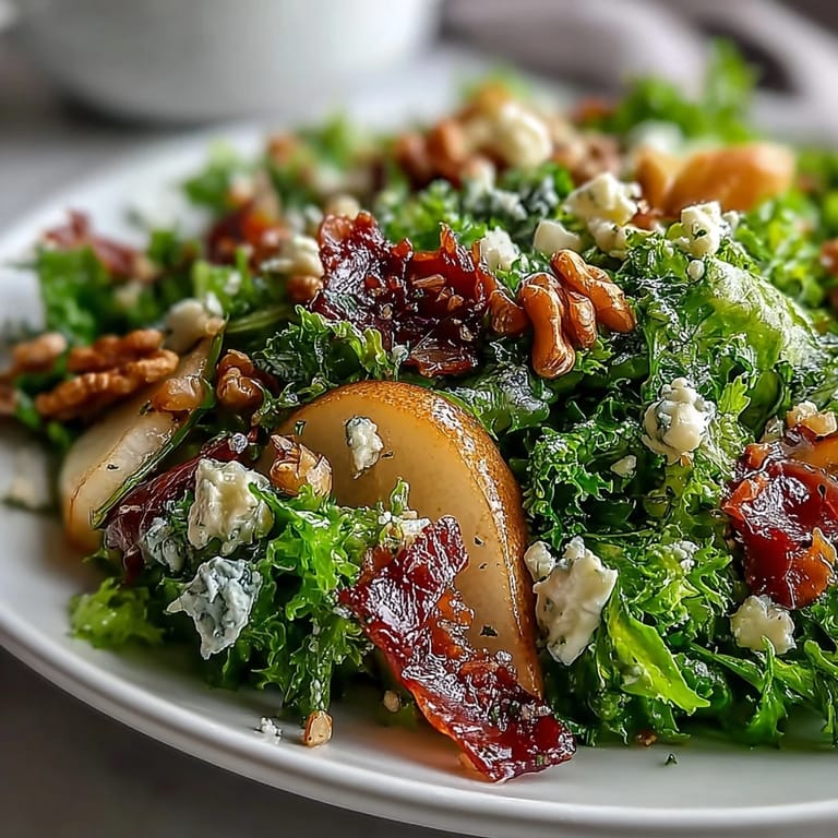 Artfully plated Frisée, Pear, Blue Cheese, and Crispy Prosciutto Salad topped with toasted walnuts, ready to serve as a light lunch.