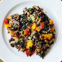 Steaming wild rice casserole with mushrooms and vegetables, a comforting vegetarian dish ready to serve.