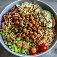 Golden roasted chickpeas and crisp veggies fill this Peanut Chickpea Protein Bowl, drizzled with creamy peanut sauce and topped with fresh cilantro.